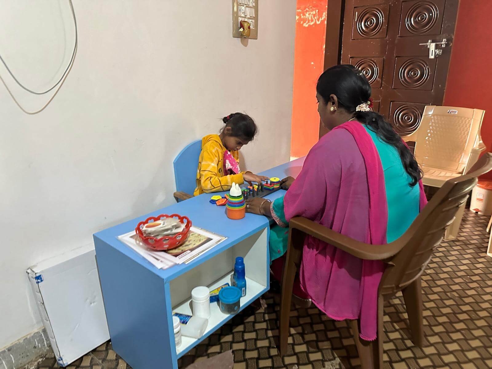 A teacher helping a student with their motor skills