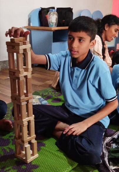 A child building a tower from Jenga
